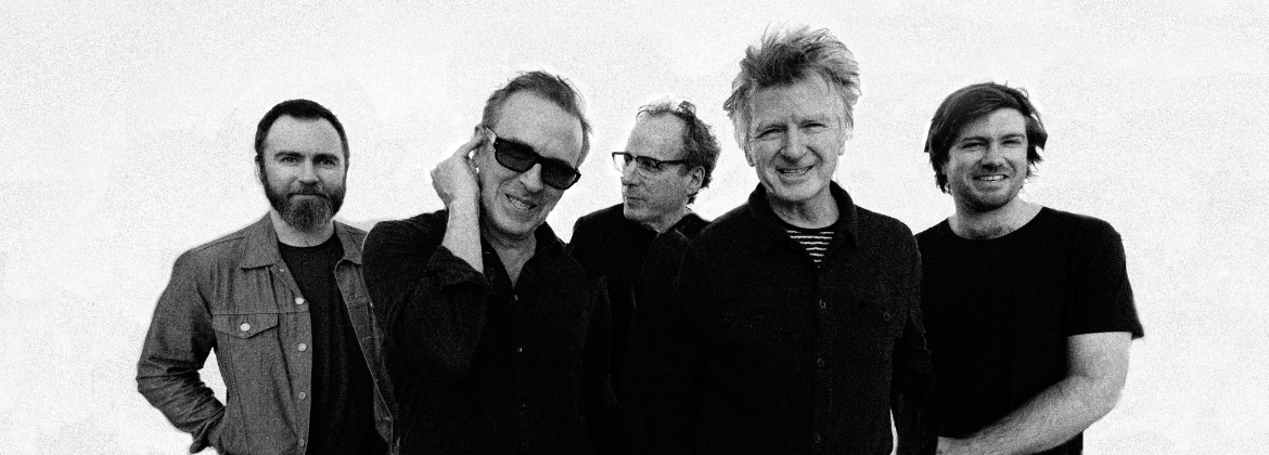 A black white photo of five men smiling at the camera