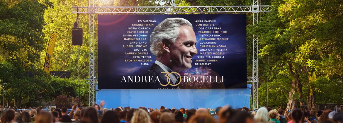 A photograph of an outdoor screen showing a clip from the film Andrea Bocelli
