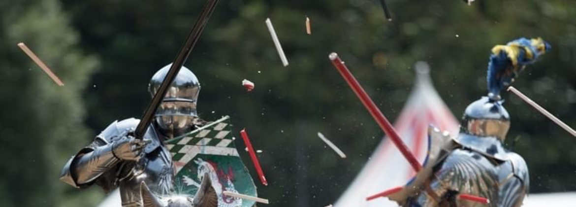 Photograph shows two Medieval Knights on horseback with lances poised in a Jousting competition
