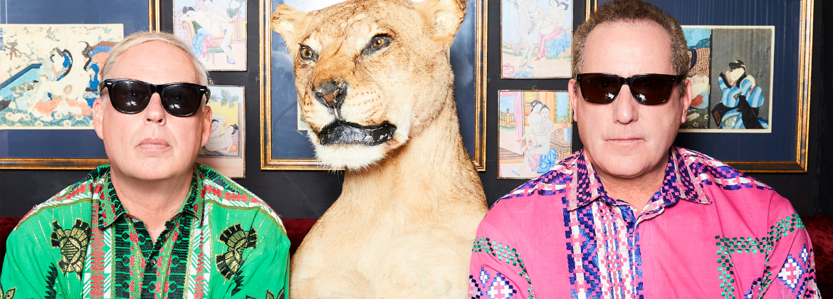 Orchestral Manoeuvres in the Dark posing next to a model of a lioness