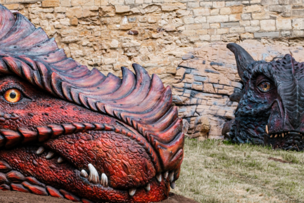 Two large dragon heads appearing from an old wall