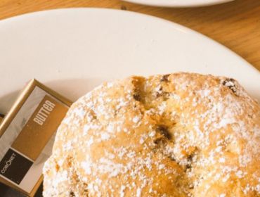 a dusted scone and butter on a plate